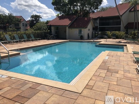 A large outdoor swimming pool surrounded by a brick patio.