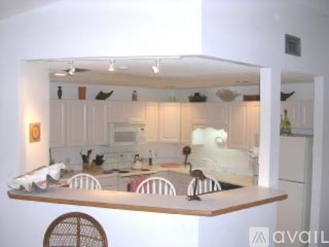 A kitchen with white cabinets and a wooden island.