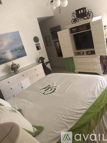 A bedroom with a bed, dresser, and a painting on the wall.