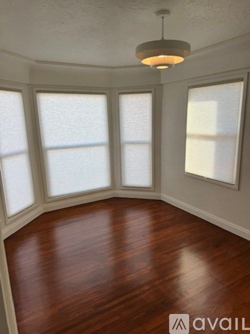 A room with wooden floors and a ceiling light.