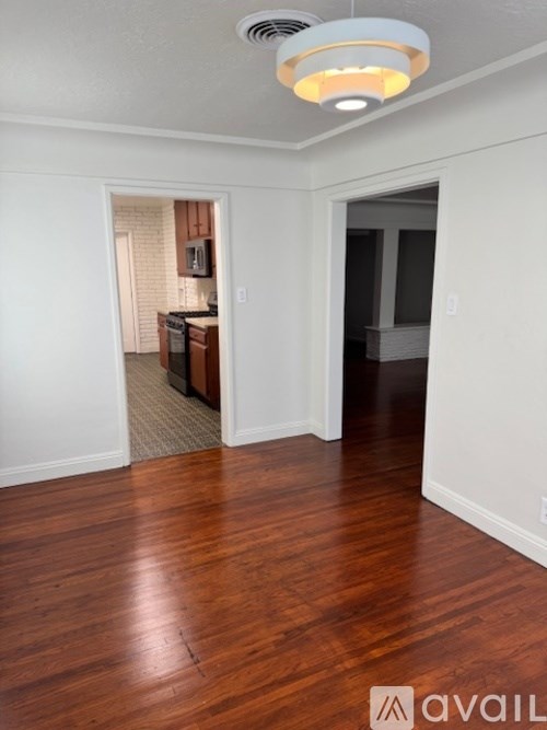 A room with wooden floors and a ceiling light.