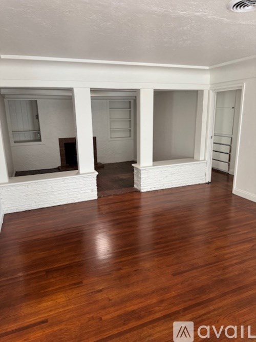 A room with wooden floors and white walls.