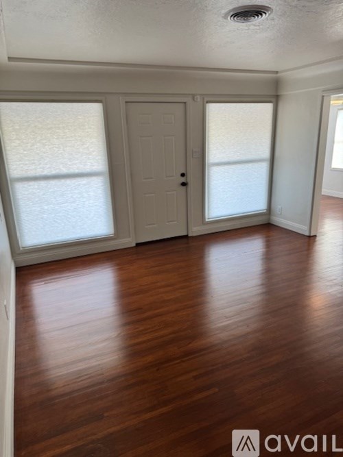 A room with wooden floors and a white door.