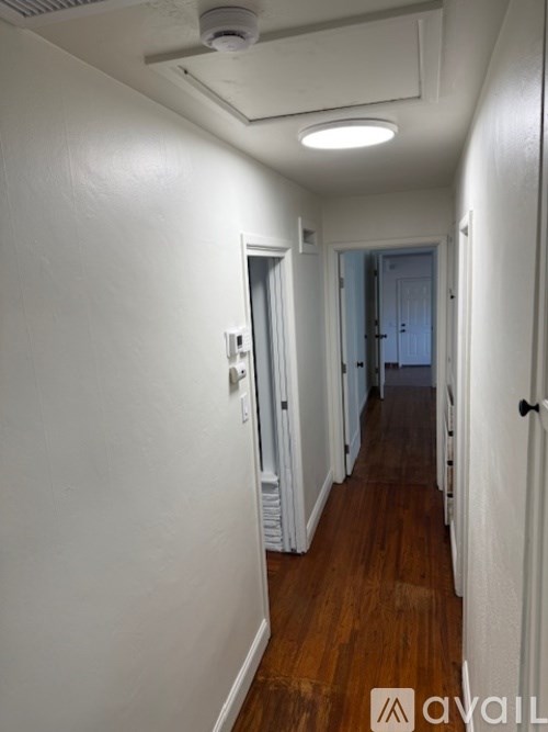 A long hallway with doors on both sides and a light on the ceiling.