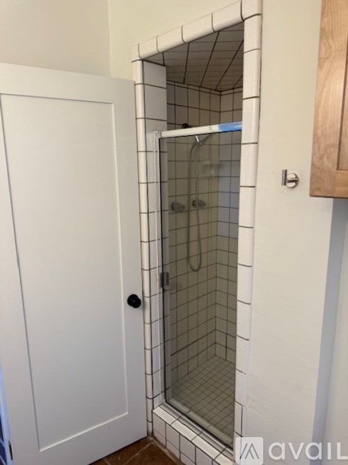 A white door with a glass shower stall in the bathroom.
