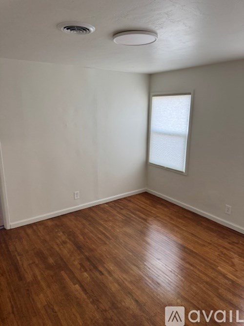 A room with wooden flooring and a window.