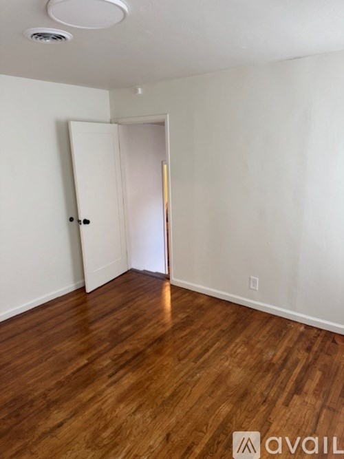 A room with a wooden floor and a white door.