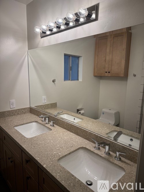 A bathroom with two sinks and a mirror.