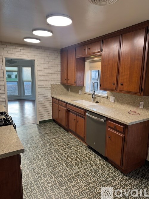 A kitchen with wooden cabinets and a patterned floor.