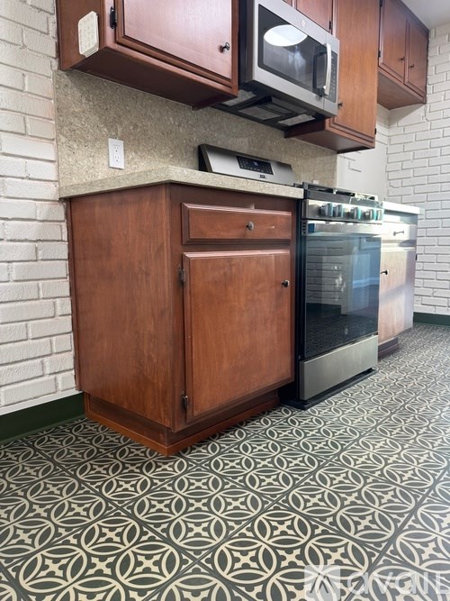 A kitchen with a wooden cabinet and a black fridge.
