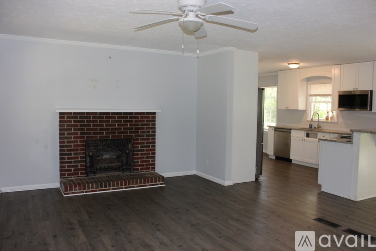 A living room with a fireplace and a ceiling fan.
