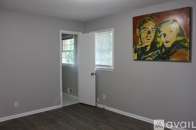 A room with a painting on the wall and a door on the right.