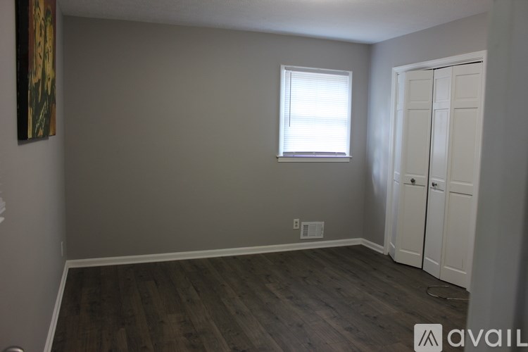 A room with a wooden floor and a white door.