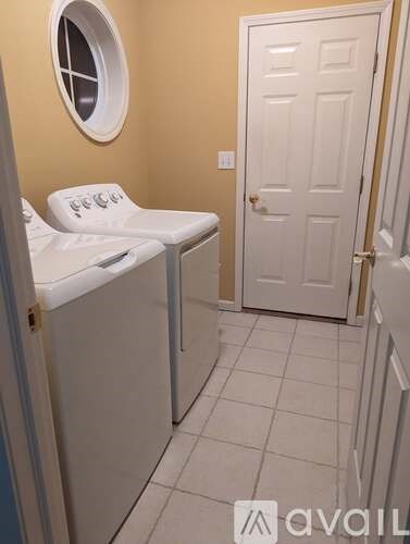 A small laundry room with a washer and dryer.