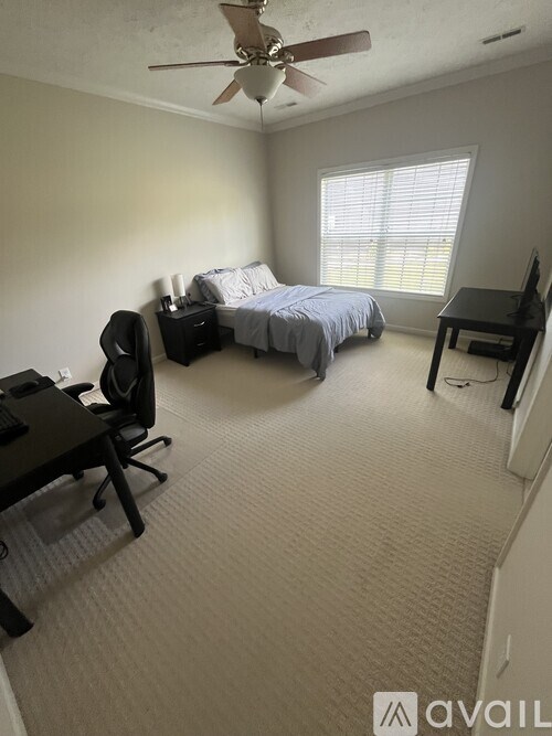 A bedroom with a bed, desk, and chair.