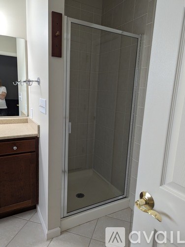 A bathroom with a glass shower door and a white door.