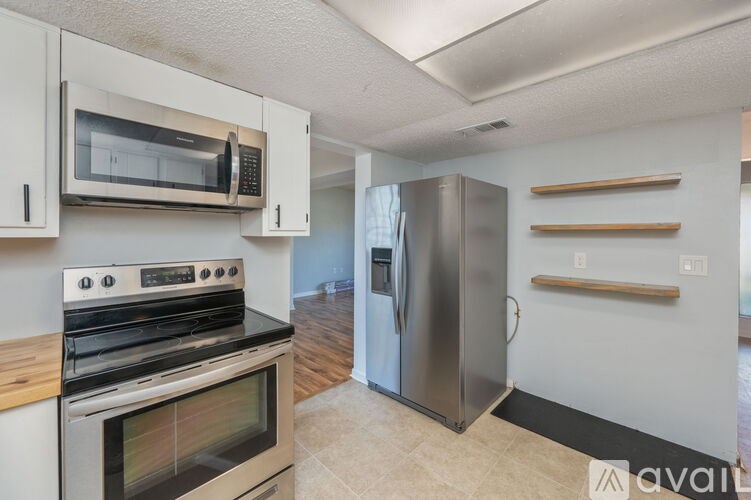 A kitchen with a stove, oven, microwave, and refrigerator.