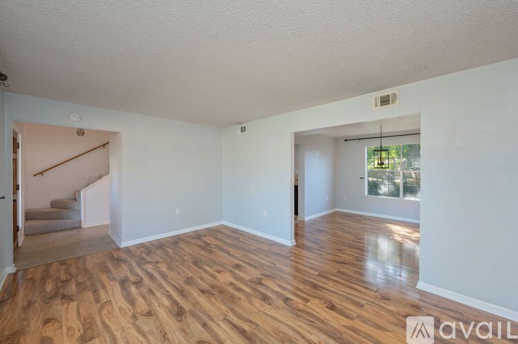 A room with wooden flooring and white walls is available for rent.