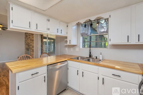 A kitchen with white cabinets and a wooden countertop.