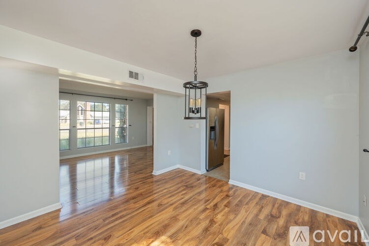A room with wooden floors and a chandelier hanging from the ceiling.