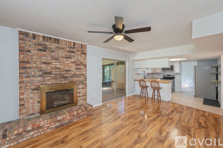 A room with a brick fireplace and wooden floors.