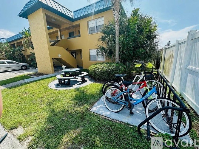 A yellow house with a blue roof and a bicycle parked in front.