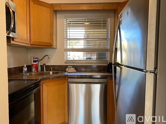 A kitchen with a stainless steel refrigerator, dishwasher, and microwave.