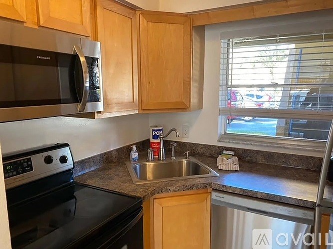 A kitchen with wooden cabinets and a stainless steel sink.