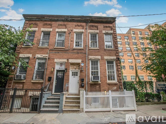 A brown brick building with a white door and windows.