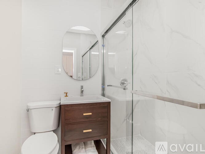 A bathroom with a toilet, sink, and mirror.