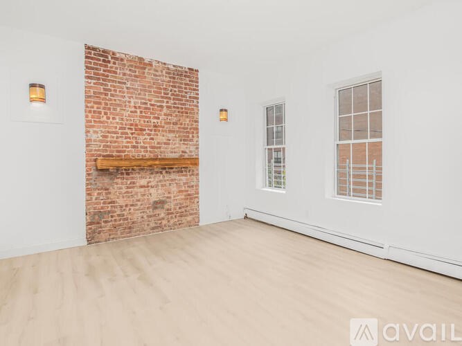 A room with a brick wall and wooden flooring.