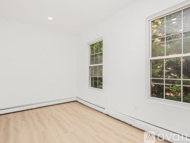 A room with a window and a wooden floor.