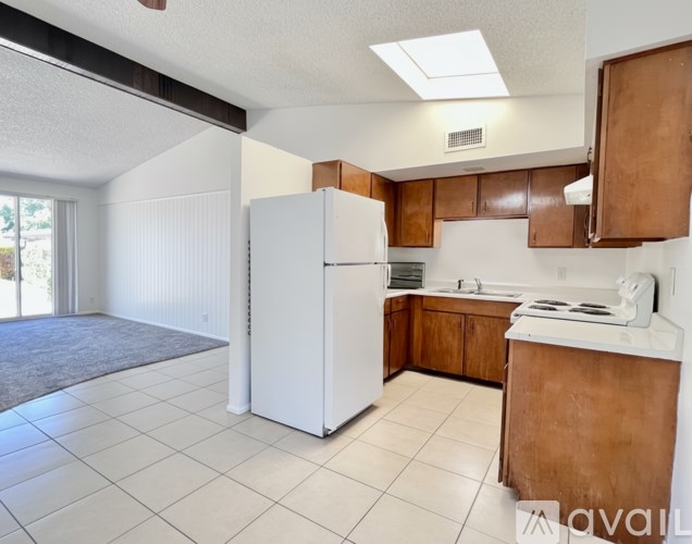 A kitchen with white appliances and brown cabinets.