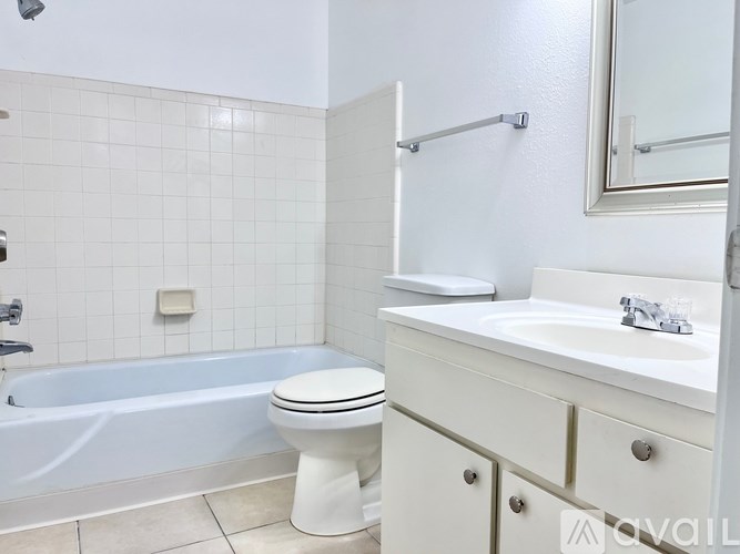 A white bathroom with a toilet, sink, and bathtub.