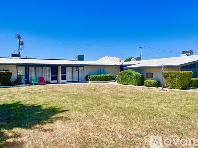 A house with a white roof and a green lawn in front.