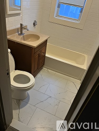A bathroom with a toilet, sink, and bathtub.