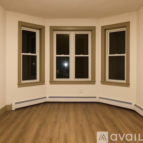 Three windows in a room with wooden floors and white walls.