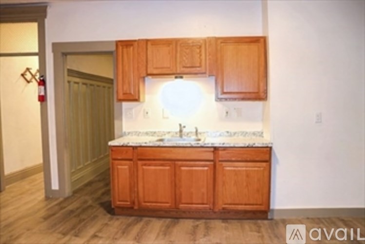 A kitchen with wooden cabinets and a marble countertop.