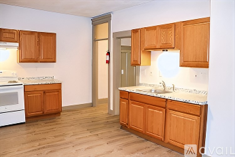 A kitchen with wooden cabinets and a white stove top oven.