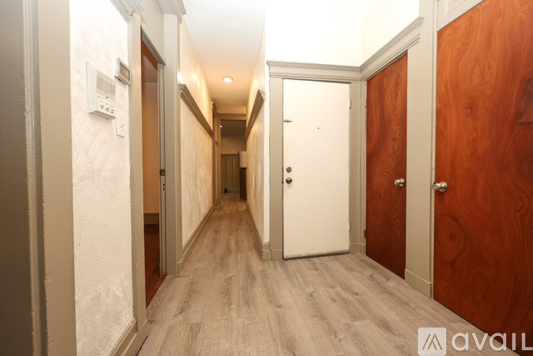 A room with a wooden floor and a brown door.