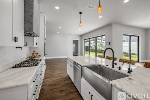 A modern kitchen with white cabinets and a marble countertop.