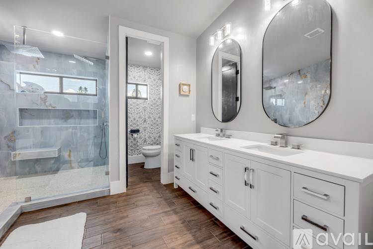 A bathroom with a marble wallpaper and a white vanity.