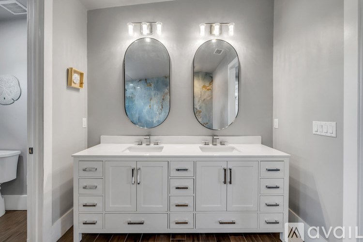 A bathroom with two sinks and a mirror above them.