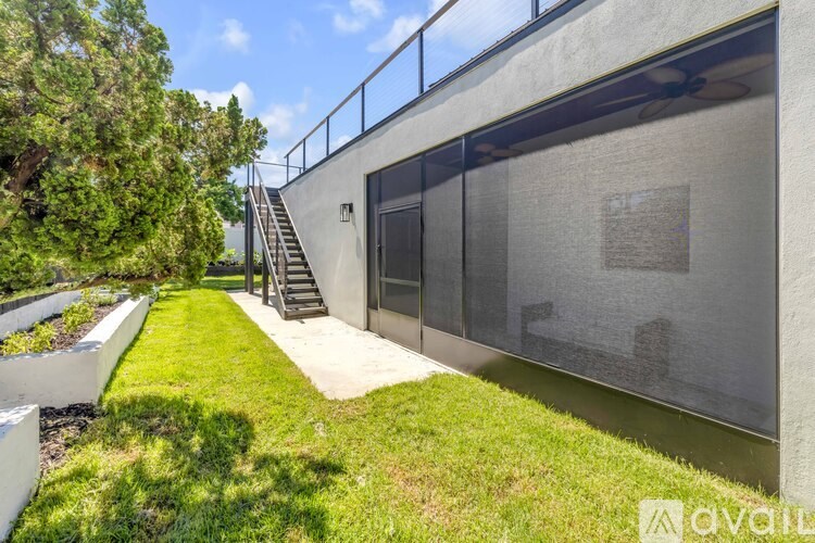 A modern building with a glass wall and a staircase leading to it.