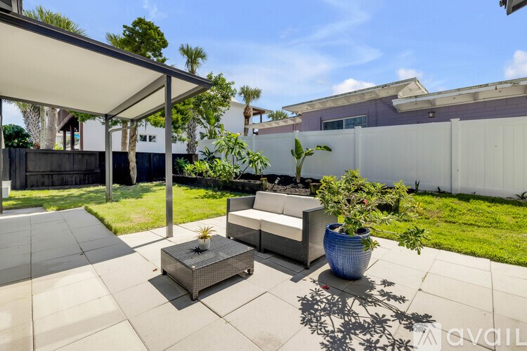 A patio with a table and chairs under a white awning.