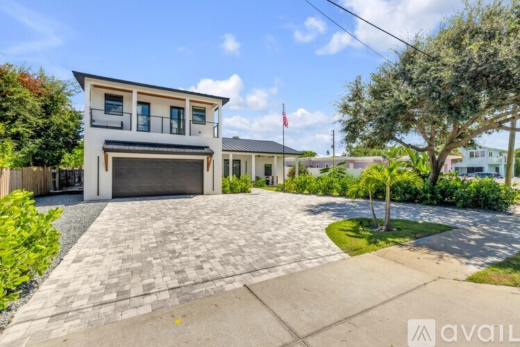 A modern house with a flag on the front lawn.