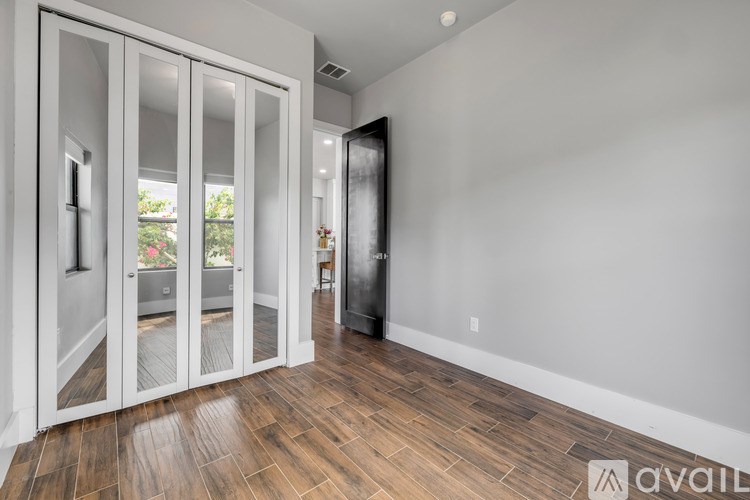 A room with a sliding door and wooden flooring.
