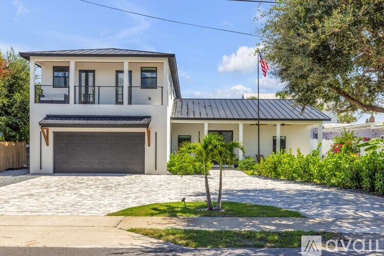 A modern two-story house with a garage and a flag on the roof.