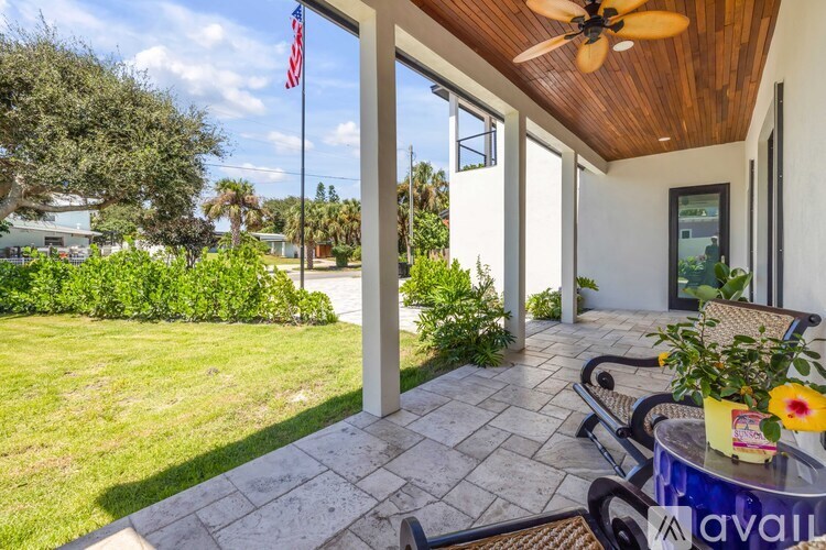 A patio with a table and chairs and a ceiling fan.