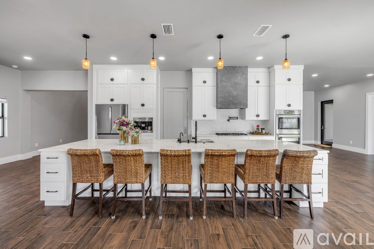 A modern kitchen with a center island and stools.